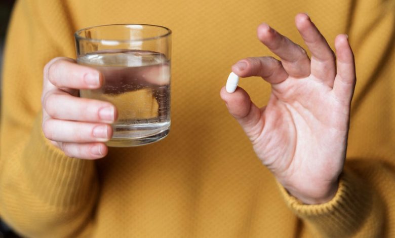 Woman holding pill
