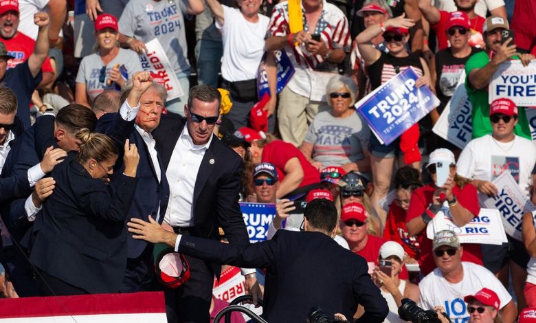 Donald Trump is seen with blood on his face surrounded by secret service