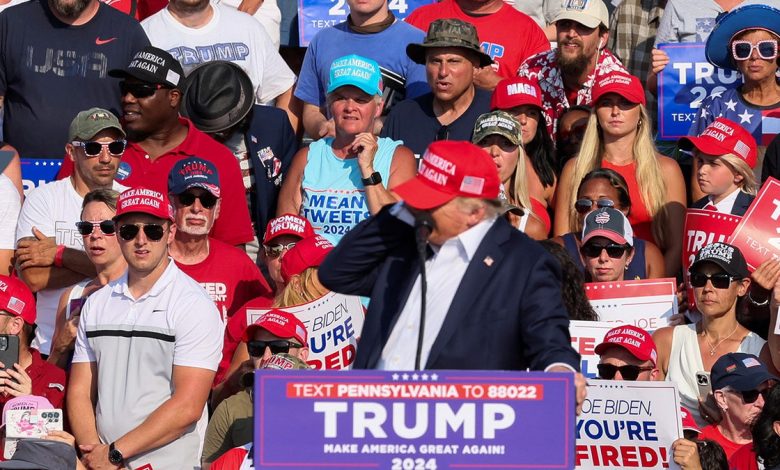 Donald Trump reacts as multiple shots rang out during a campaign rally