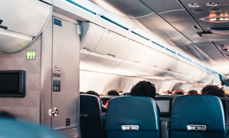 airplane passengers are seated next to the bathroom