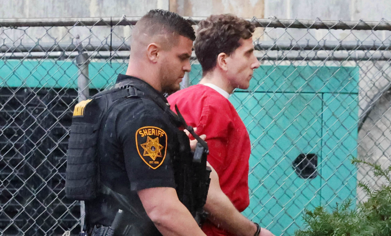 Bryan Kohberger in a red jail jumpsuit being escorted by a deputy into a Pennsylvania courthouse