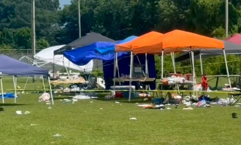 crime scene tape around tents and debris on grass