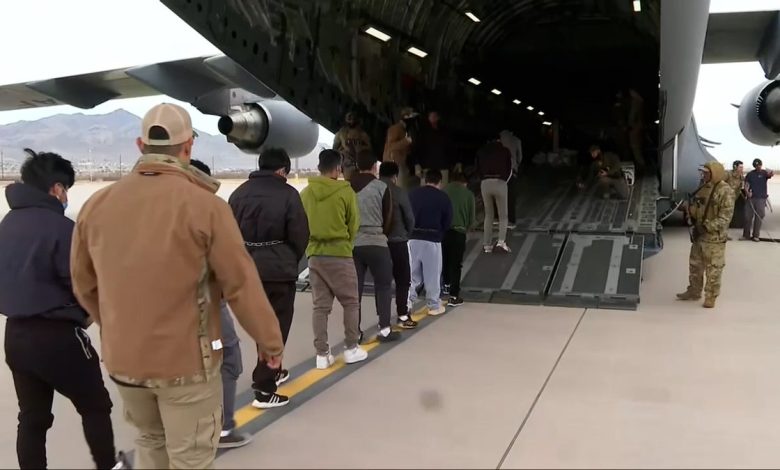 row of people walking into military plane