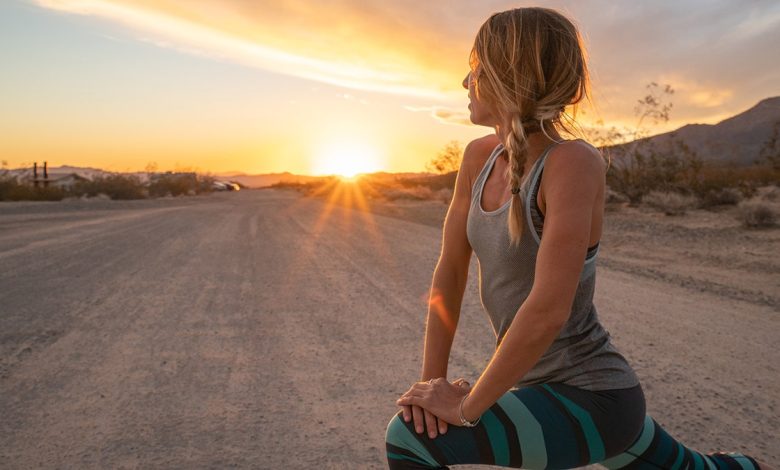 woman stretching at sunrise outside