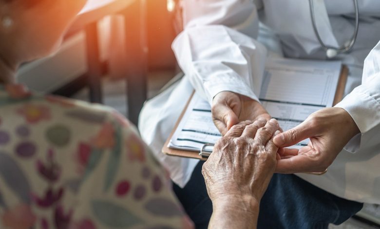 Parkinson's disease patient holding doctor's hand