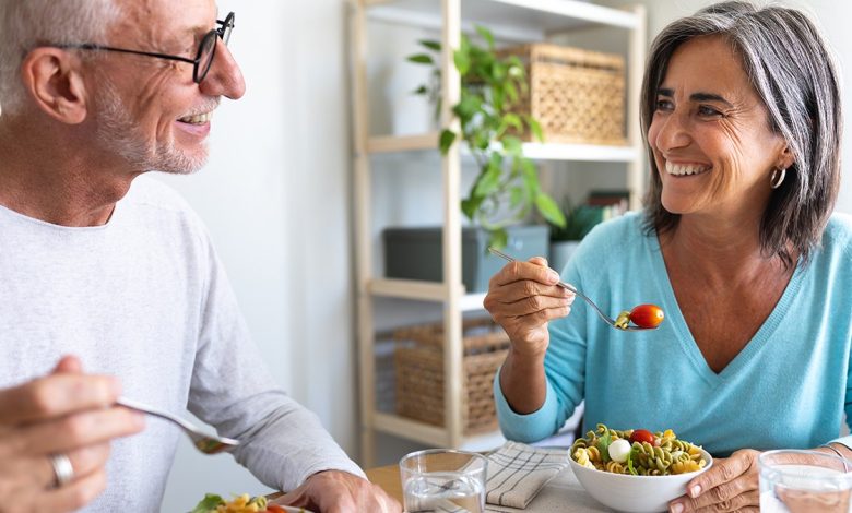 senior couple enjoying pasta salad for lunch