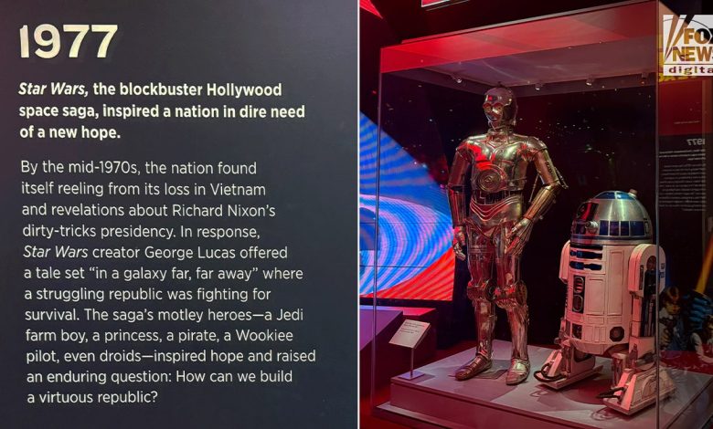 C-3PO and R2-D2 at Smithsonian exhibit with panel praising Star Wars